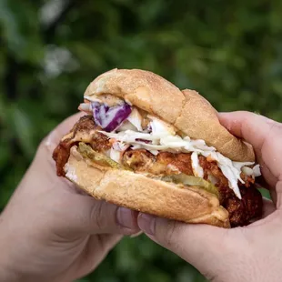 a person holding a sandwich in their hand