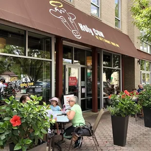 people sitting at tables outside a restaurant