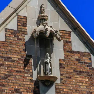 a statue of a man and a woman on the side of a building