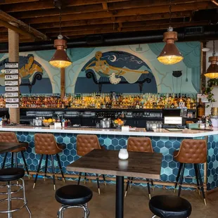 a bar with stools and tables