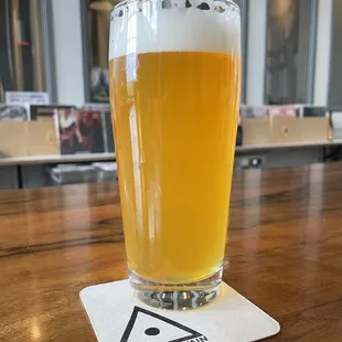 a glass of beer on a coaster