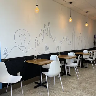 a dining area with white chairs and tables