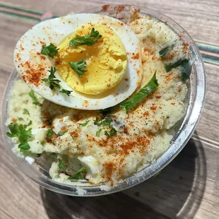 a bowl of mashed potatoes with a hard boiled egg