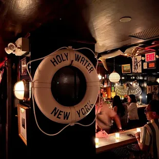 people sitting at a bar with a life preserver on the wall
