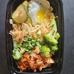 Vegetarian bowl with delicious Korean banchans (Korean style sides) and fried egg (sunny side up)