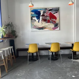 three yellow chairs and a painting on the wall