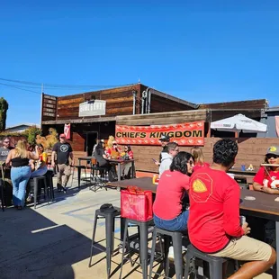 a group of people sitting at tables outside a restaurant