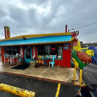 a colorful rooster statue in front of a restaurant