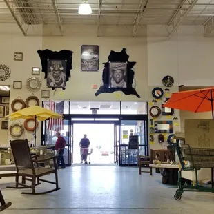 Sitting on a rocking chair right inside the entrance facing the front.