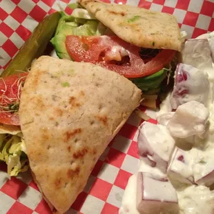 Avocado sandwich on flatbread with red-skinned potato salad.