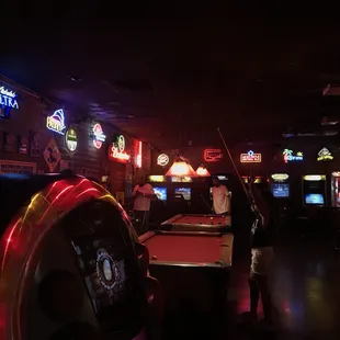 a pool table and neon signs