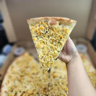 a hand holding a slice of pizza