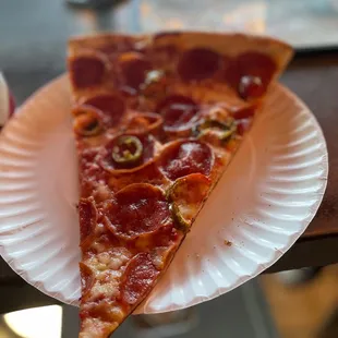 a slice of pizza on a paper plate