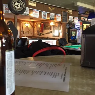 a table with a bottle of beer and a menu