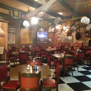 a checkered floor with red chairs