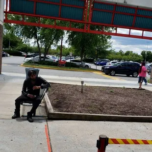 a man sitting on a bench in a parking lot