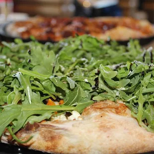 The Pigs &amp; Pears pizza is made with Roasted Garlic Base, Mozzarella, Parmesan, Goat Cheese, Butternut Squash, Candied Pear, Bacon, &amp; Arugula