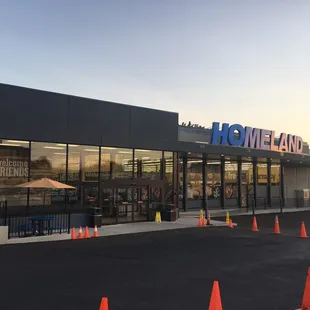 the front of a store with orange cones in front of it
