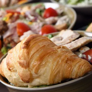 a croissant sandwich and salad
