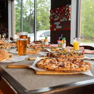 a table of pizzas and drinks
