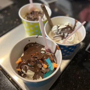 two cups of ice cream with chocolate and sprinkles