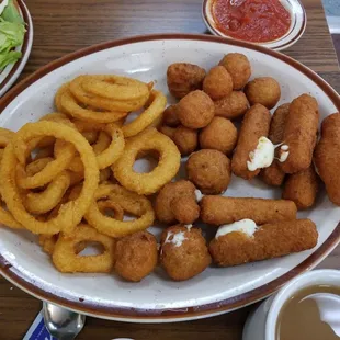 a plate of onion rings, onion rings, and salad