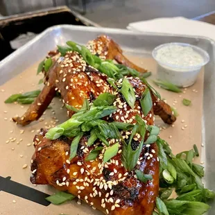 ows a plate of chicken with sesame seeds and green onions