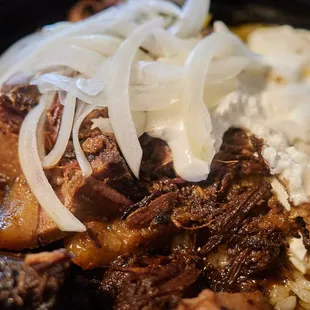 Burnt end and brisket chili w/ onions and sour cream (there is rice under the mountain of beef)