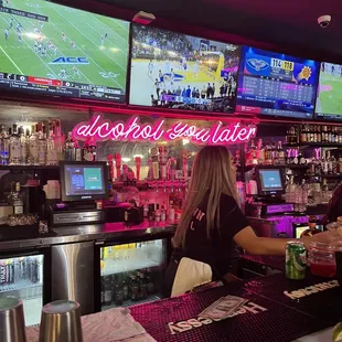 a woman sitting at a bar watching a football game