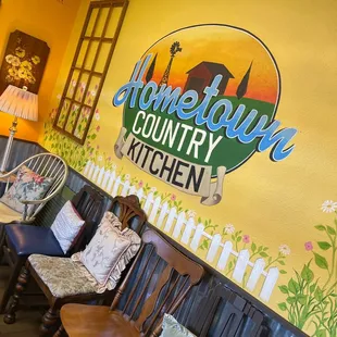 a row of chairs in front of a painted wall