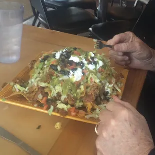 a person cutting a large plate of food