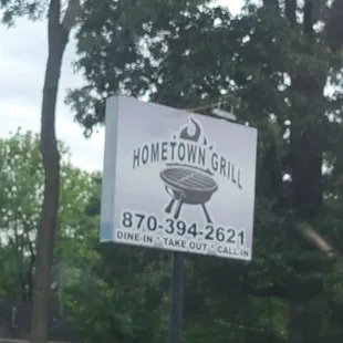 a sign in front of a tree