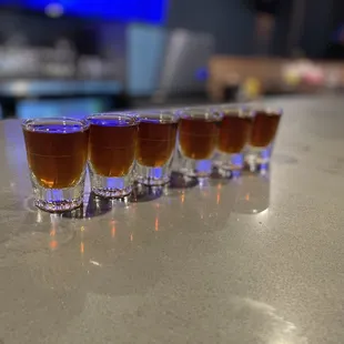 a row of shot glasses on a bar