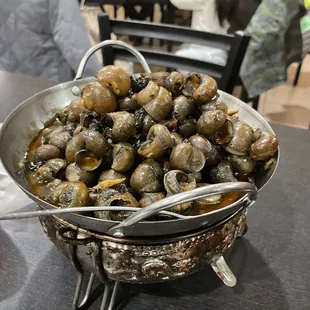 a bowl of snails and a can of soda