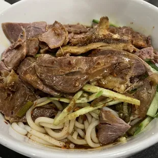 a bowl of noodles with meat and vegetables