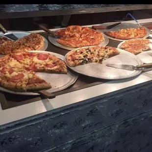 a variety of pizzas on display