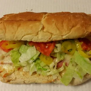 a sub sandwich with lettuce, tomato, and cheese