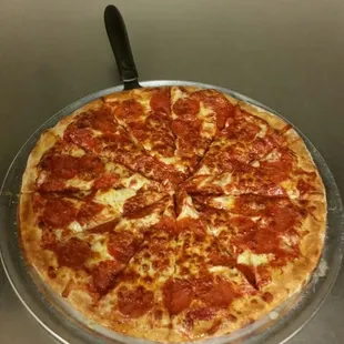 a pepperoni pizza on a pizza pan