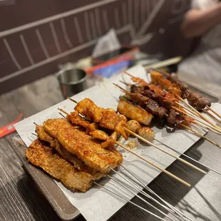 several skewers of food on a tray