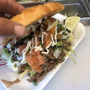 a hand holding a sandwich