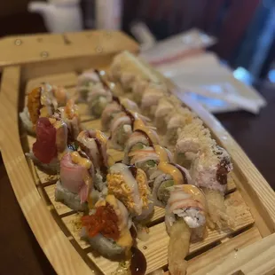 a wooden tray with a variety of sushi