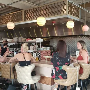 Bar area near front, where you can see them cooking.
