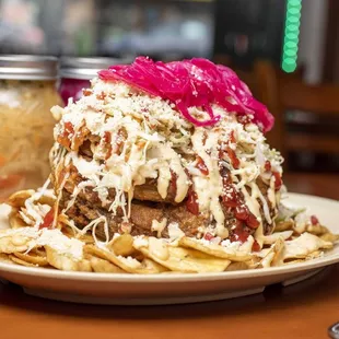 a plate of nachos and a jar of pickles