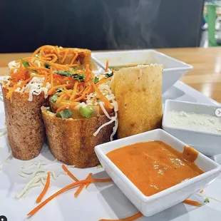 a plate of food with bread and dips