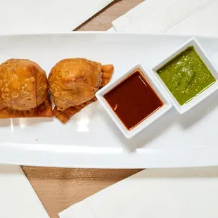 a plate of food with dipping sauces