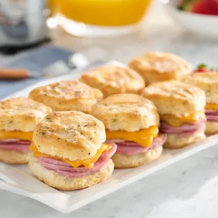 a plate of biscuits with ham and cheese