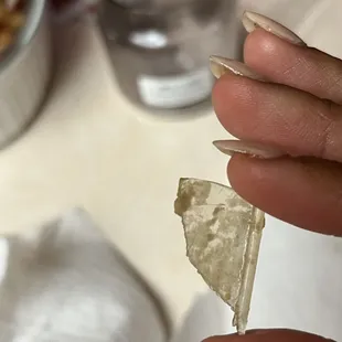 a hand holding a piece of bread