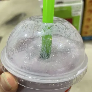 a purple drink with a green straw