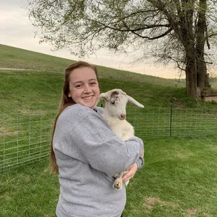 a woman holding a goat