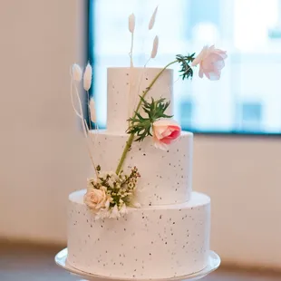 Textured three-tiered cake with modern floral arrangement. Image courtesy of Adrien Craven Photography.